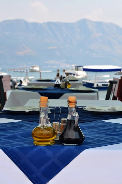 Garrafa de azeite e vinagre balsâmico italiano sobre toalha de mesa azul — Fotografia de Stock