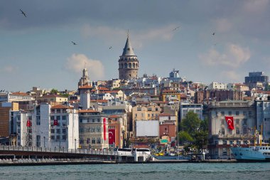 Deniz manzaralı, sahilde evler, eski kule ve manzaralı bir şehir. Golden Horn Körfezi, Galata Kulesi. İstanbul, Türkiye. Seyahat, manzara