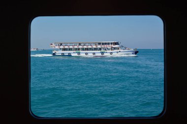 Tekne bir deniz gemisinin penceresinde yüzüyor. Siyah çerçeveli deniz. İstanbul, Türkiye 'ye Seyahat.