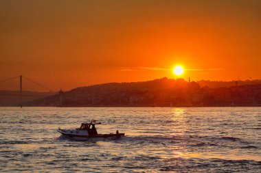 Küçük bir tekne güneşin doğuşuna karşı denizde yüzüyor. İstanbul, Türkiye 'ye Seyahat.