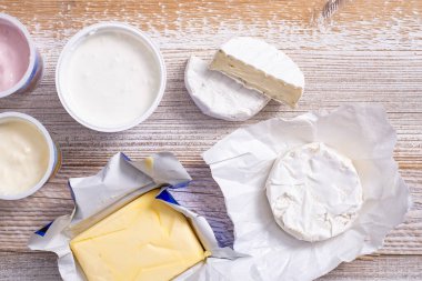 Yoghurt and cheeses on a wooden table.