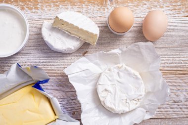 Yoghurt and cheeses on a wooden table.