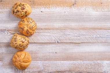 Buns with grains on a wooden table.