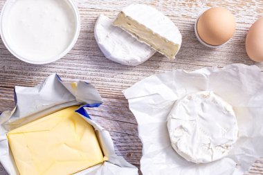 Yoghurt and cheeses on a wooden table.