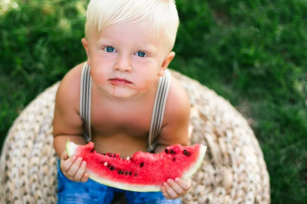 child eating watermelon on the grass