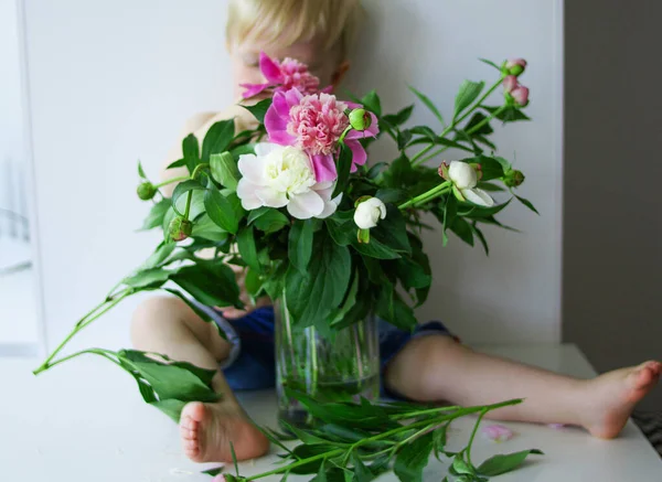 small child hiding behind flowers