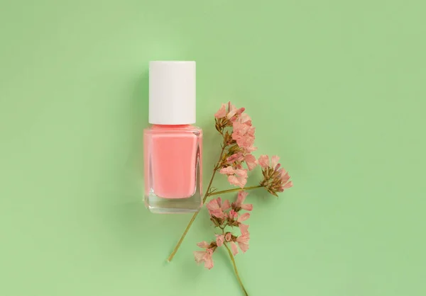 pink nail polish on green background