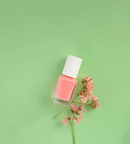 pink nail polish on green background