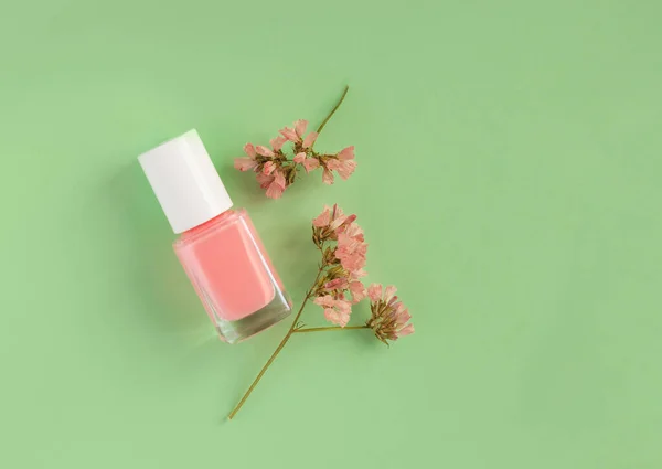 pink nail polish on green background