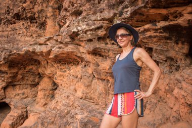 Brezilya, Maranhao 'daki Chapada da Mesas' ta güneş batarken kırmızı kayalıklara vuran kadın.