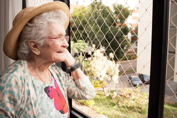 Starší Žena Doma Dívá Okna Svého Bytu Stock Snímky