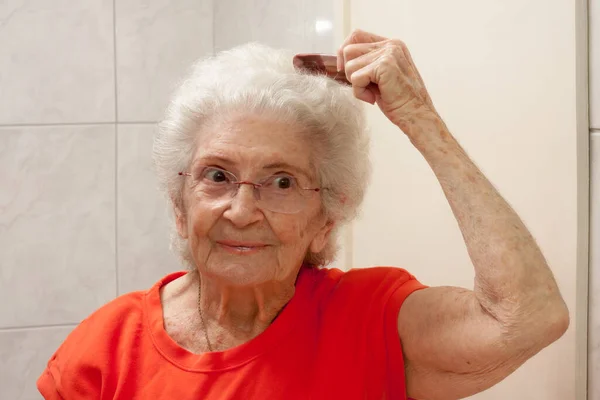 Anziana Signora Pettinarsi Capelli Davanti Uno Specchio Bagno — Foto Stock