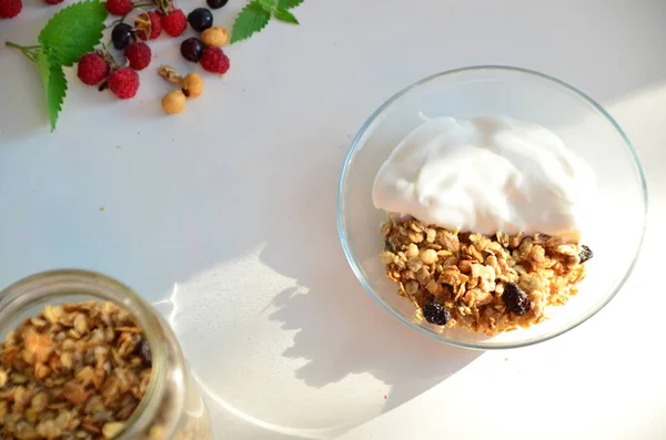 Vasul de mic dejun sănătos cu granola de casă. nutriție adecvată castron de granola de ovăz cu iaurt, zmeură proaspătă, afine, căpșuni, nuci de mure cu lingură pe alb pentru alimente sănătoase — Fotografie, imagine de stoc