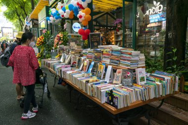 Ho Chi Minh Şehri, Vietnam - 10 Ekim 2021: Ziyaretçiler, Ho Chi Minh City, Vietnam 'da yayalar üzerindeki sanat severler için yol kenarında satılık kitaplar satın almayı seçiyorlar