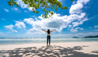 Phu Quoc, Vietnam - 4 Mart 2021: Gezgin Asyalı kadınların silueti güneşli bir öğleden sonra Phu Quoc Adası, Vietnam 'da cennet kumsalını seyrediyor