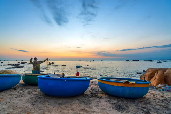Mui Ne, Vietnam - 24 Ocak 2022: Gün batımında balıkçılar ağlarına takılıp ertesi sabah Mui Ne, Vietnam 'da denize açılmaya hazırlanırken sepet tekne rıhtımının manzarası