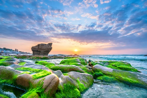 Rocky plajı ve yeşil yosun gündoğumunda gökyüzünde Orta Vietnam 'da güzel bir plajda