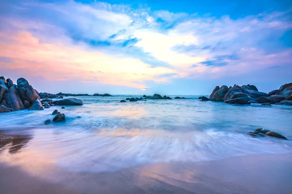 Güneşin doğuşunda güzel bir sahil. Dalgaların altında. Huzurlu yeni güne hoş geldin demek için yumuşak büyük sahilde tur atıyor.