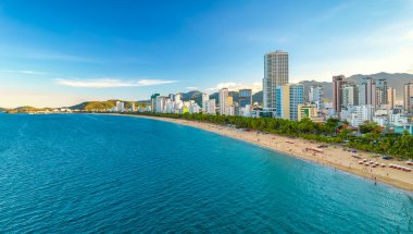 Nha Trang, Vietnam - 25 Mart 2022: Güzel şehri ve temiz kumlu plajı ile öğleden sonra yukarıdan görülen kıyı kenti Nha Trang, Vietnam 'ı ziyaret etmek için turistleri cezbediyor.