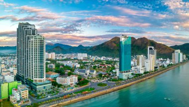 Nha Trang, Vietnam - 25 Mart 2022: Güzel şehri ve temiz kumlu plajı ile öğleden sonra yukarıdan görülen kıyı kenti Nha Trang, Vietnam 'ı ziyaret etmek için turistleri cezbediyor.