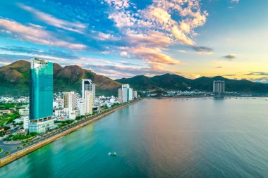Nha Trang, Vietnam - 25 Mart 2022: Güzel şehri ve temiz kumlu plajı ile öğleden sonra yukarıdan görülen kıyı kenti Nha Trang, Vietnam 'ı ziyaret etmek için turistleri cezbediyor.