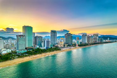 Nha Trang, Vietnam - 25 Mart 2022: Güzel şehri ve temiz kumlu plajı ile öğleden sonra yukarıdan görülen kıyı kenti Nha Trang, Vietnam 'ı ziyaret etmek için turistleri cezbediyor.