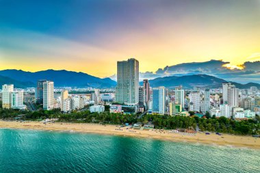 Nha Trang, Vietnam - 25 Mart 2022: Güzel şehri ve temiz kumlu plajı ile öğleden sonra yukarıdan görülen kıyı kenti Nha Trang, Vietnam 'ı ziyaret etmek için turistleri cezbediyor.