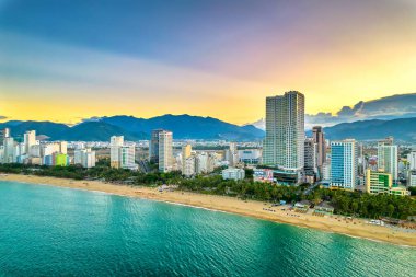 Nha Trang, Vietnam - 25 Mart 2022: Güzel şehri ve temiz kumlu plajı ile öğleden sonra yukarıdan görülen kıyı kenti Nha Trang, Vietnam 'ı ziyaret etmek için turistleri cezbediyor.