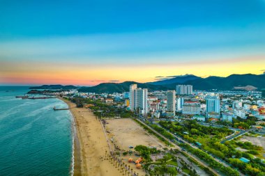 Nha Trang, Vietnam - 25 Mart 2022: Güzel şehri ve temiz kumlu plajı ile öğleden sonra yukarıdan görülen kıyı kenti Nha Trang, Vietnam 'ı ziyaret etmek için turistleri cezbediyor.