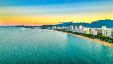 Nha Trang, Vietnam - 25 Mart 2022: Güzel şehri ve temiz kumlu plajı ile öğleden sonra yukarıdan görülen kıyı kenti Nha Trang, Vietnam 'ı ziyaret etmek için turistleri cezbediyor.