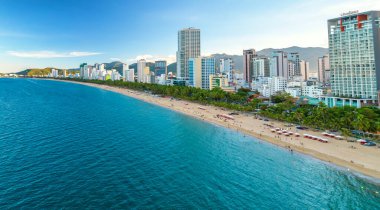 Nha Trang, Vietnam - 25 Mart 2022: Güzel şehri ve temiz kumlu plajı ile öğleden sonra yukarıdan görülen kıyı kenti Nha Trang, Vietnam 'ı ziyaret etmek için turistleri cezbediyor.