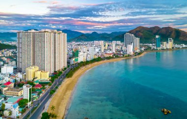 Nha Trang, Vietnam - 25 Mart 2022: Güzel şehri ve temiz kumlu plajı ile öğleden sonra yukarıdan görülen kıyı kenti Nha Trang, Vietnam 'ı ziyaret etmek için turistleri cezbediyor.