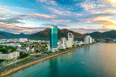 Nha Trang, Vietnam - 25 Mart 2022: Güzel şehri ve temiz kumlu plajı ile öğleden sonra yukarıdan görülen kıyı kenti Nha Trang, Vietnam 'ı ziyaret etmek için turistleri cezbediyor.