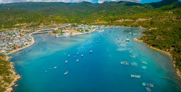 Vinh Hy Körfezi yazın öğleden sonra yüzlerce balıkçı teknesi demirli ve balıkçı köyleriyle yukarıdan izlendi. Burası Ninh Thuan, Vietnam 'da ziyaret edilecek güzel bir koy.