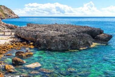 Yazın öğle vakti güzel körfezde volkanik kaya plajı..