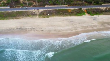 The waves crashing on the golden sand are so beautiful from above, the beach is for relaxing and bathing