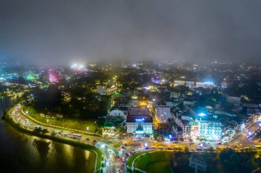 Aerial view of Da Lat city night beautiful tourism destination in central highlands Vietnam. Urban development texture, green parks and city lake.
