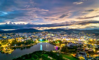 Da Lat şehrinin hava manzarası. Gün batımı gökyüzü. Orta dağlık Vietnam 'da güzel bir turizm merkezi. Kentsel gelişim dokusu, yeşil parklar ve şehir gölü.