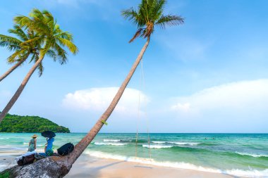 Phu Quoc, Vietnam - 18 Nisan 2022: İnci adasındaki güzel tropik plaj. Bu açık ve mavi, turistleri cezbedip hafta sonları Phu Quoc, Vietnam 'da eğlendirmek için uzanan kumlar.