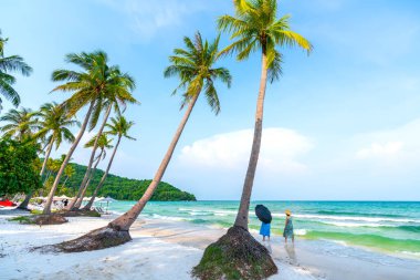 Phu Quoc, Vietnam - 18 Nisan 2022: İnci adasındaki güzel tropik plaj. Bu açık ve mavi, turistleri cezbedip hafta sonları Phu Quoc, Vietnam 'da eğlendirmek için uzanan kumlar.