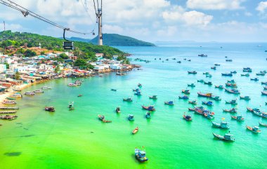 Dünyanın en uzun teleferik yolculuğu Güney Vietnam 'daki Phu Quoc adası. Aşağıda, popüler Hon Thom adasındaki An Thoi kasabasının limanında sıralanmış geleneksel balıkçı tekneleri var. Seyahat kavramı.