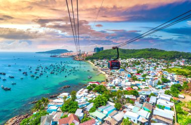 Dünyanın en uzun teleferik yolculuğu Güney Vietnam 'daki Phu Quoc adası, günbatımı gökyüzü. Aşağıda, popüler Hon Thom adasındaki An Thoi kasabasının limanında sıralanmış geleneksel balıkçı tekneleri var.. 