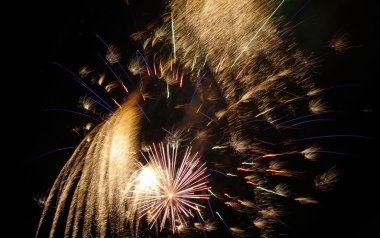 Karanlık gökyüzünde renkli havai fişekler