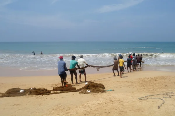 I pescatori dello Sri Lanka tirano grandi reti a Induruwa, Sri Lanka. La pesca è un'occupazione chiave sulla costa del mare dello Sri Lanka . — Foto Stock