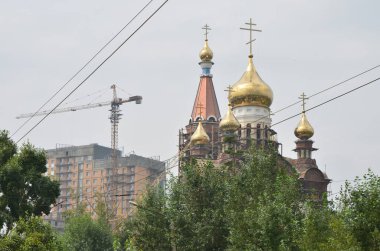 Bu resim kiliseyi ve vinçli binayı gösteriyor.