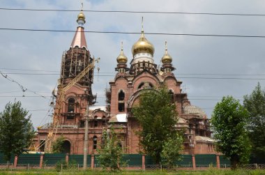 Bu resim ağaçları ve yolları olan bir kiliseyi gösteriyor.