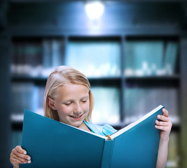 Petite fille lisant un grand livre Image En Vente