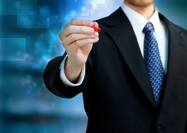 Hombre de negocios sosteniendo una pluma roja — Foto de Stock