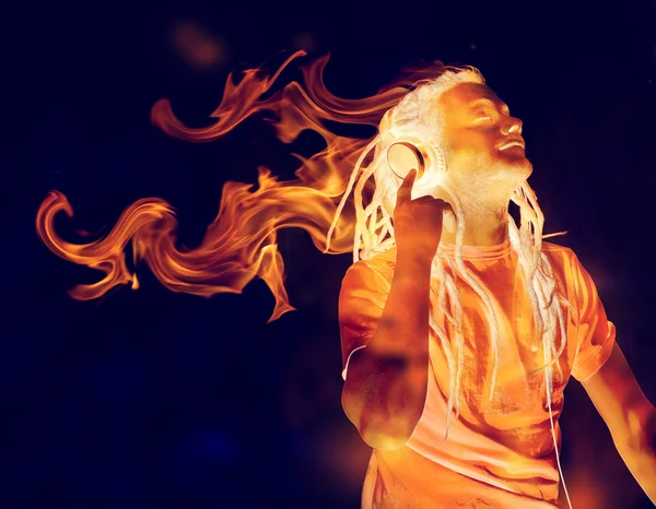 Man Listening to Music on Headphones in Flames — Stock Photo, Image