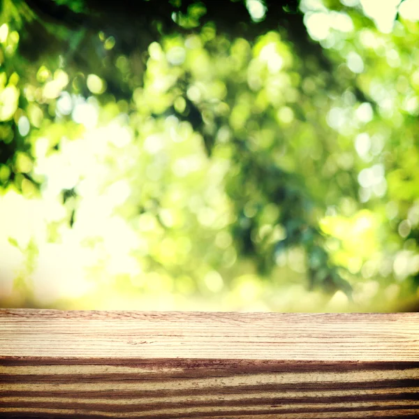 Выдержанные деревянные доски на фоне листвы — стоковое фото